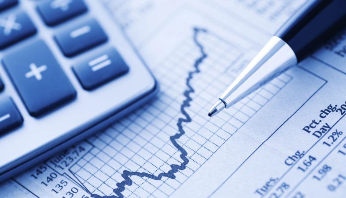 Close-up of a Calculator and Pen on a Financial Newspaper. Blue-toned.